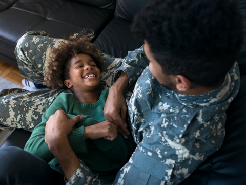 Service member sitting with child
