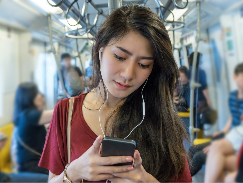 woman on a bus looking at a mobile device