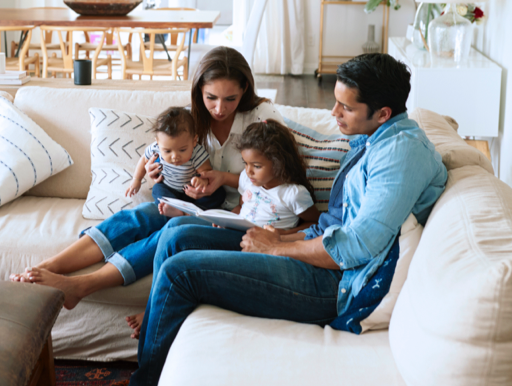 family on the couch reading a book